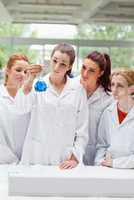 Portrait of science students looking at a flask