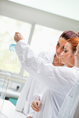 Cute chemistry students looking at a liquid