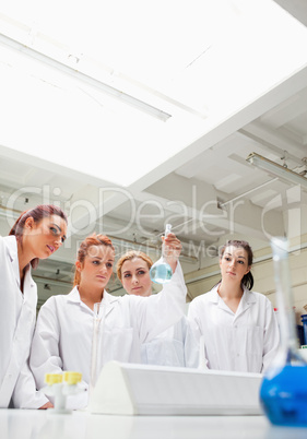 Cute chemistry students looking at a fkask