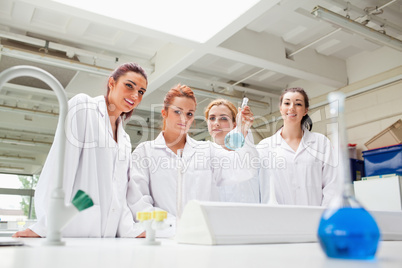 Smiling chemistry students holding a flask