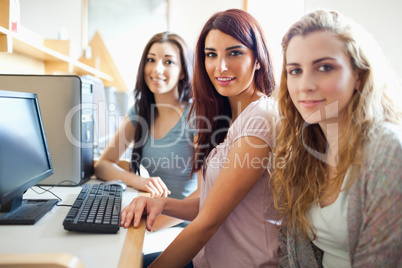Cute fellow students posing with a computer