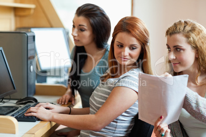 Smiling student showing her notes to her classmate