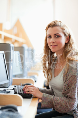 Portrait of a cute student posing with a computer