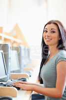 Portrait of a gorgeous student posing with a computer