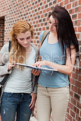 Portrait of a student showing something to her classmate