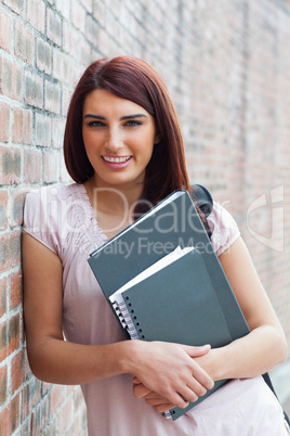 Portrait of a happy student holding her binders