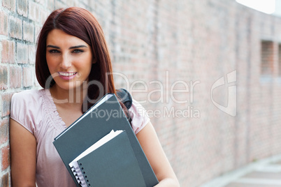 Happy student holding her binders