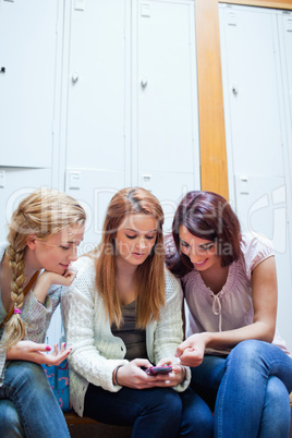 Portrait of a student showing a text message to her friends