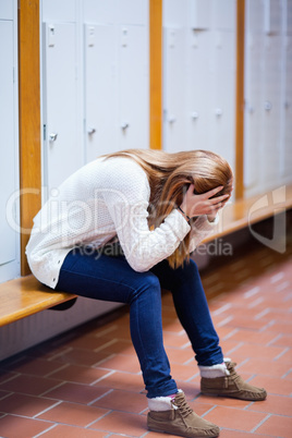 Portrait of a depressed student sitting on a bench