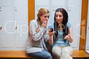 Surprised student showing a text message to her friend