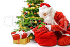 Weihnachtsmann legt Geschenke unter den Christbaum