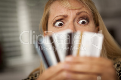 Upset Woman Glaring At Her Many Credit Cards