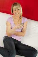 Attractive young woman on the couch with the phone