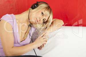 Attractive young woman on a sofa with headphones