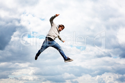 Junger Mann springt vor Freude in die Luft