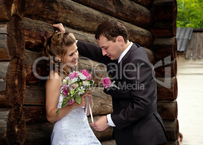 young wedding couple alone near wood house