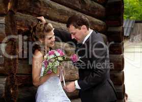 young wedding couple alone near wood house