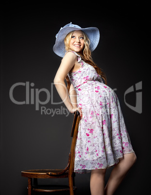 Blond pregnant woman portrait in straw hat