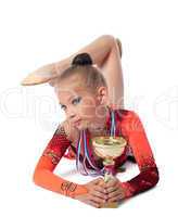 young gymnast lay with medal and prize cup
