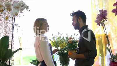 Young woman and client talking in flowers shop