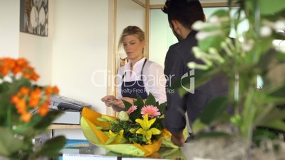 Sales manager at counter and client shopping in flowers shop