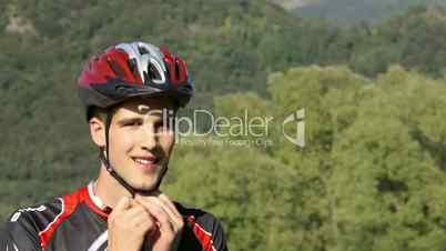 Young man training on mountain bike and looking at river landscape