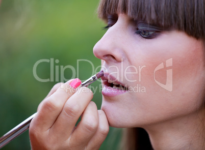 Makeup master applying lipstick