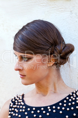 Caucasian girl with opened eyes in black dress with pearls