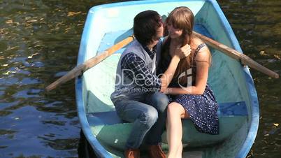 A young couple kissing in a boat