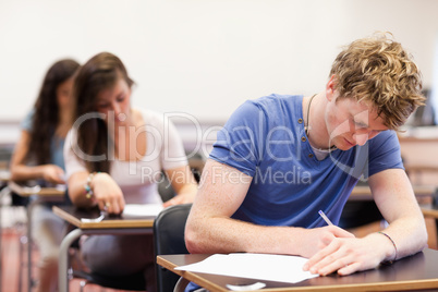 Handsome student writing an assignment
