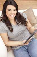 Happy Hispanic Woman Using Tablet Computer At Home