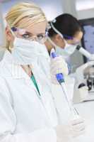 Female Scientist Doctors, Pipette & Microscope in a Laboratory