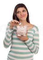 Ethnic Female Putting Coin Into Piggy Bank on White