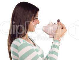 Ethnic Female Putting Coin Into Piggy Bank on White