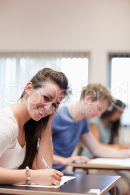 Portrait of a smiling woman writing