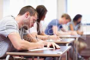 Handsome student writing an assignment