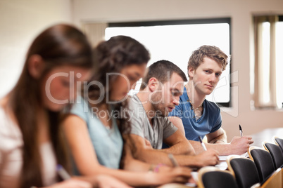 Students listening a lecturer with the camera focus on the foreg