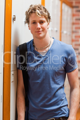 Portrait of a smiling student leaning on a locker