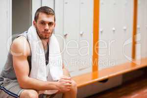 Handsome sports student sitting on a bench