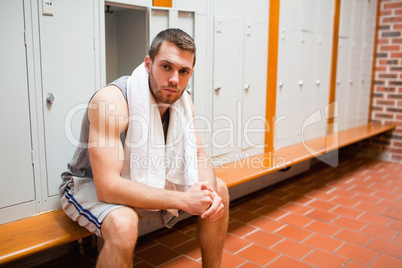Handsome young sports student sitting on a bench