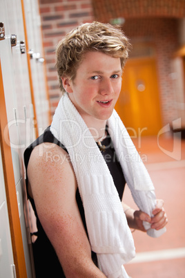 Portrait of a sports student leaning on a locker