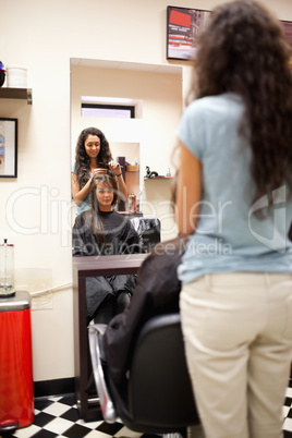 Portrait of a woman combing the hair of a customer