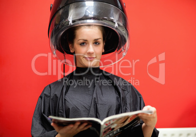 Young woman under a hairdressing machine