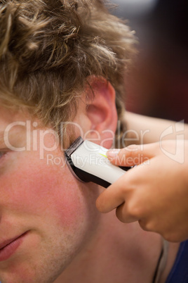 Portrait of a young man having a haircut