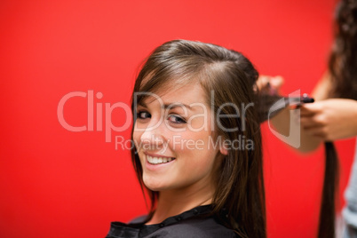 Young woman having her hair straightened