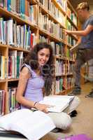 Portrait of a student with a book while her classmate is choosin