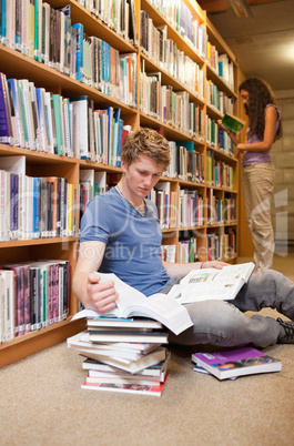 Portrait of a male student making research while his classmate i