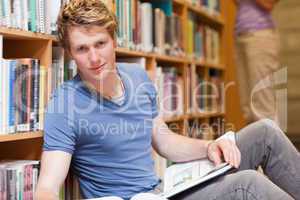 Handsome student posing with a book
