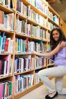 Portrait of a smiling female student choosing a book