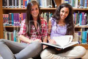 Smiling female students with a book